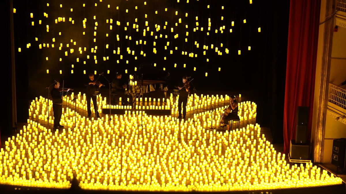 O quarteto de cordas no palco sob a chuva de velas
